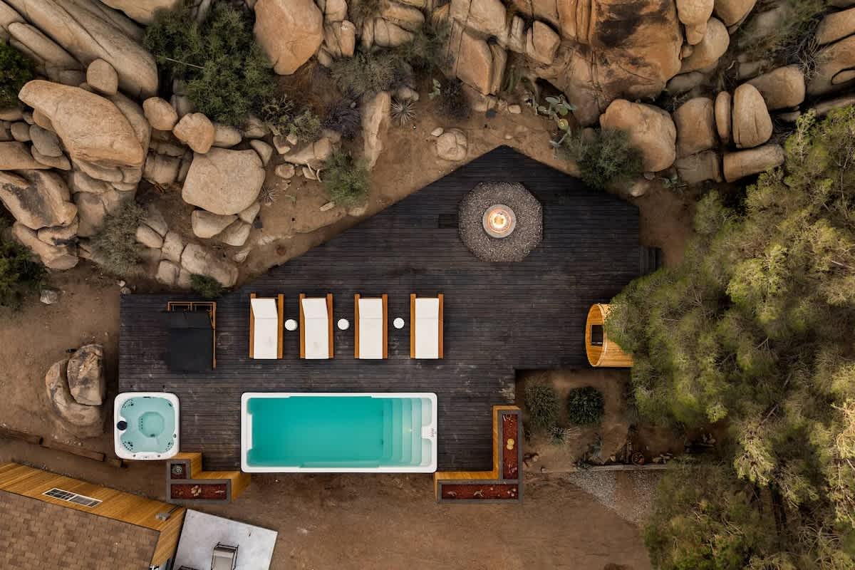 Aerial view of an 8x20 fiberglass container pool with surrounding deck and fire pit in Joshua Tree, California