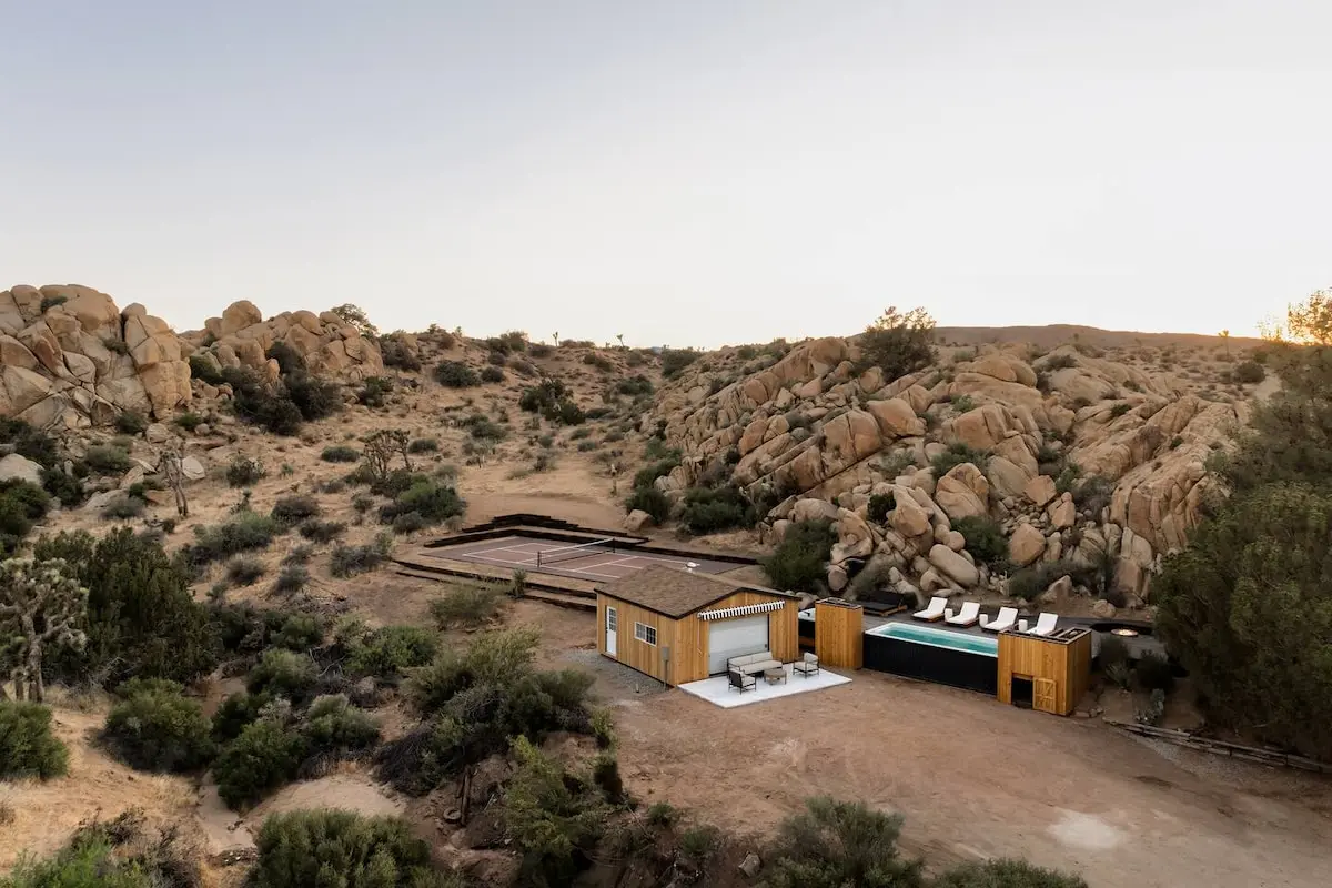 Container pool set into a hillside at Desert Remedy in Joshua Tree, California, with the steel container wall exposed and wood cladding on the ends