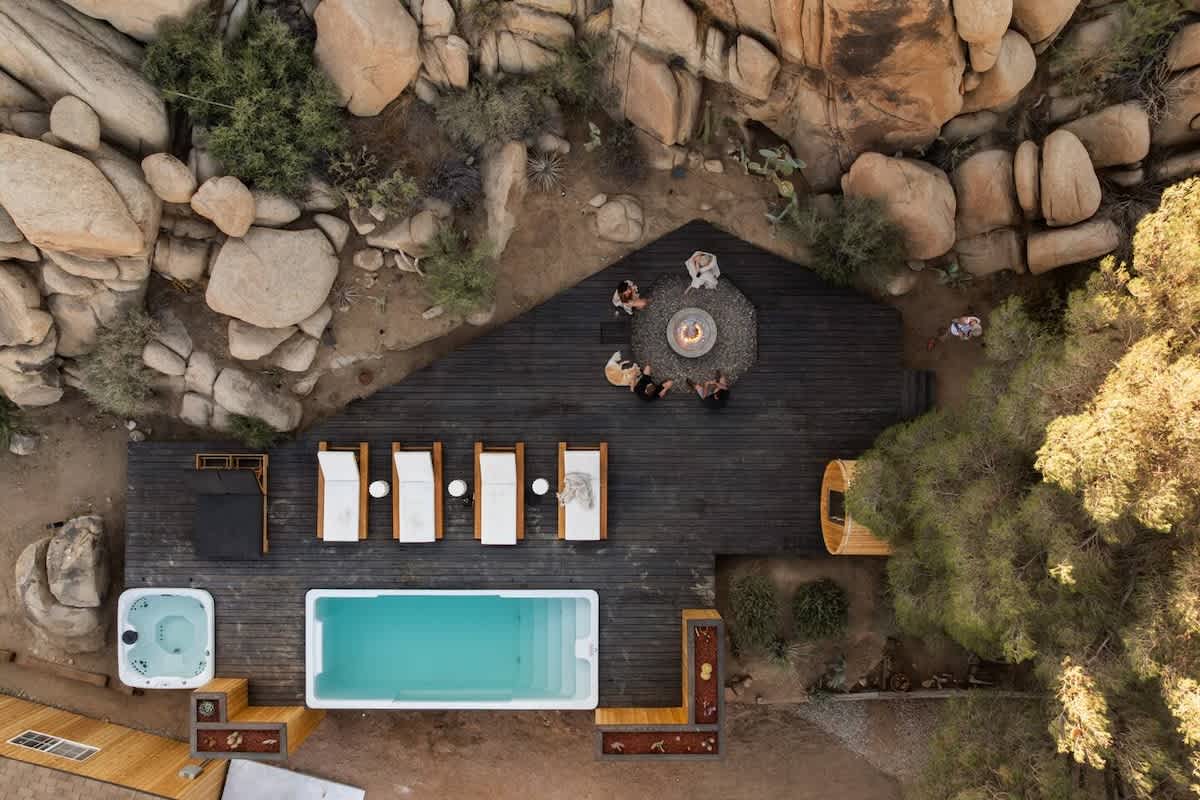 Overhead view of container pool, deck, and fire pit with guests, Joshua Tree, California
