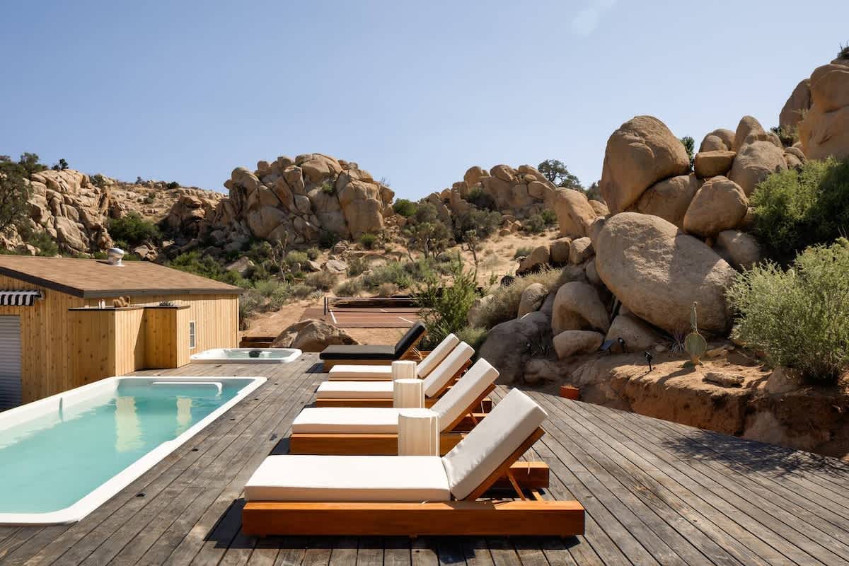 Fiberglass container pool on a wood deck surrounded by desert boulders, Joshua Tree, California