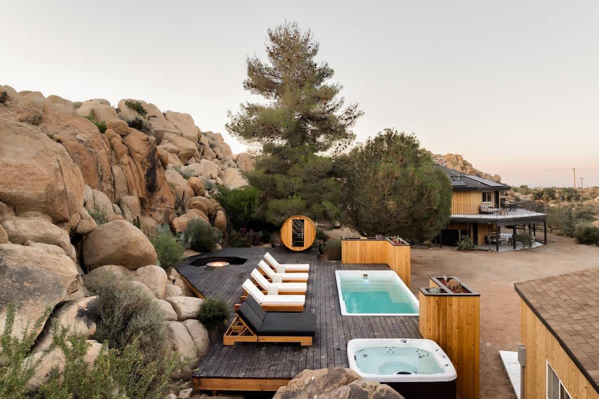 Container pool and hot tub at dusk with desert home in background, Joshua Tree, California