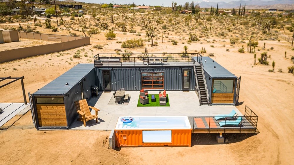 Aerial view of an orange container pool and container home compound in the Joshua Tree desert, California