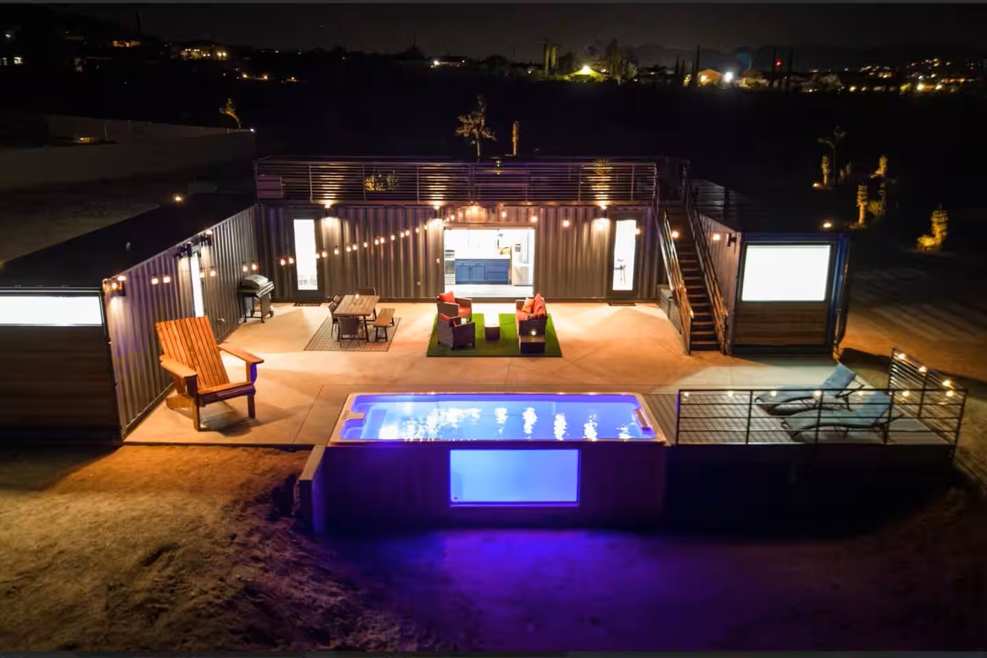 Container pool lit purple at night beside a container home in Joshua Tree, California