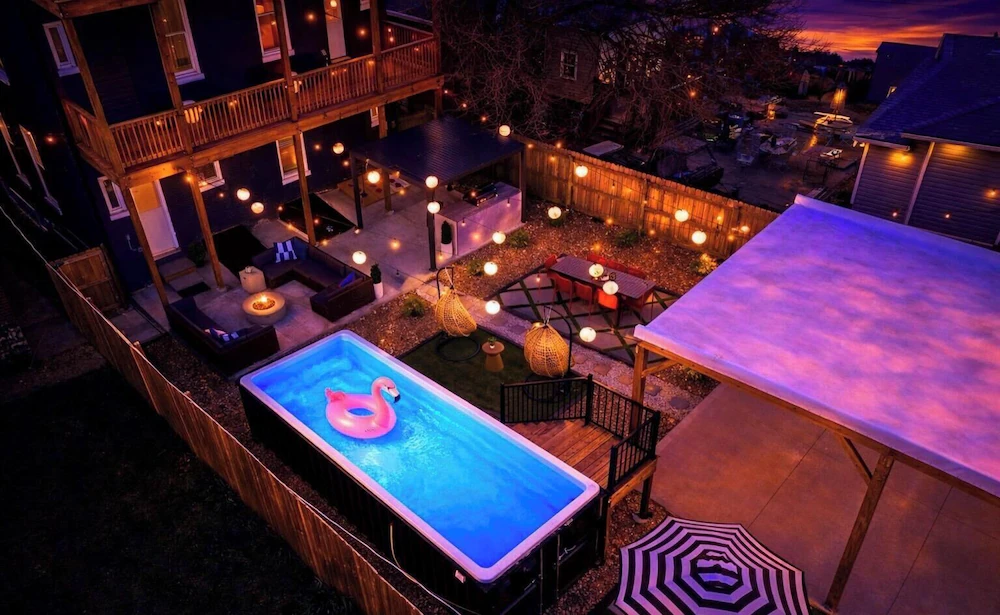 Container pool lit blue at night with an acrylic window in a St. Louis backyard