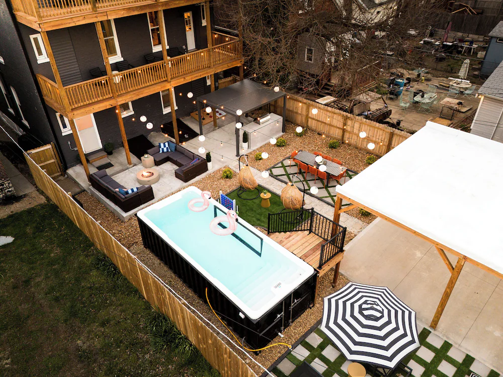 Container pool with white fiberglass interior and black exterior in an urban St. Louis backyard with patio and deck